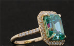 Side view of a 4 CT green emerald cut moissanite engagement ring with a diamond halo and yellow gold band.