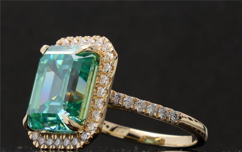 Angled close-up perspective of the vibrant green emerald cut moissanite ring in yellow gold.