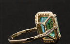 Macro perspective capturing the intricate prongs and halo craftsmanship of the green moissanite ring.