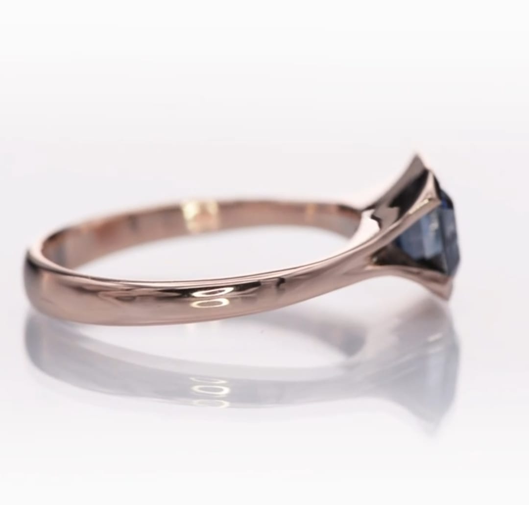 Profile view highlighting the low-profile bezel setting and polished rose gold shank.