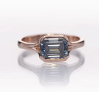 Top-down view of the 2 CT grey emerald cut moissanite gemstone framed in rose gold.