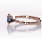 Clean side profile view of the bezel-set grey moissanite stone and tapered band.