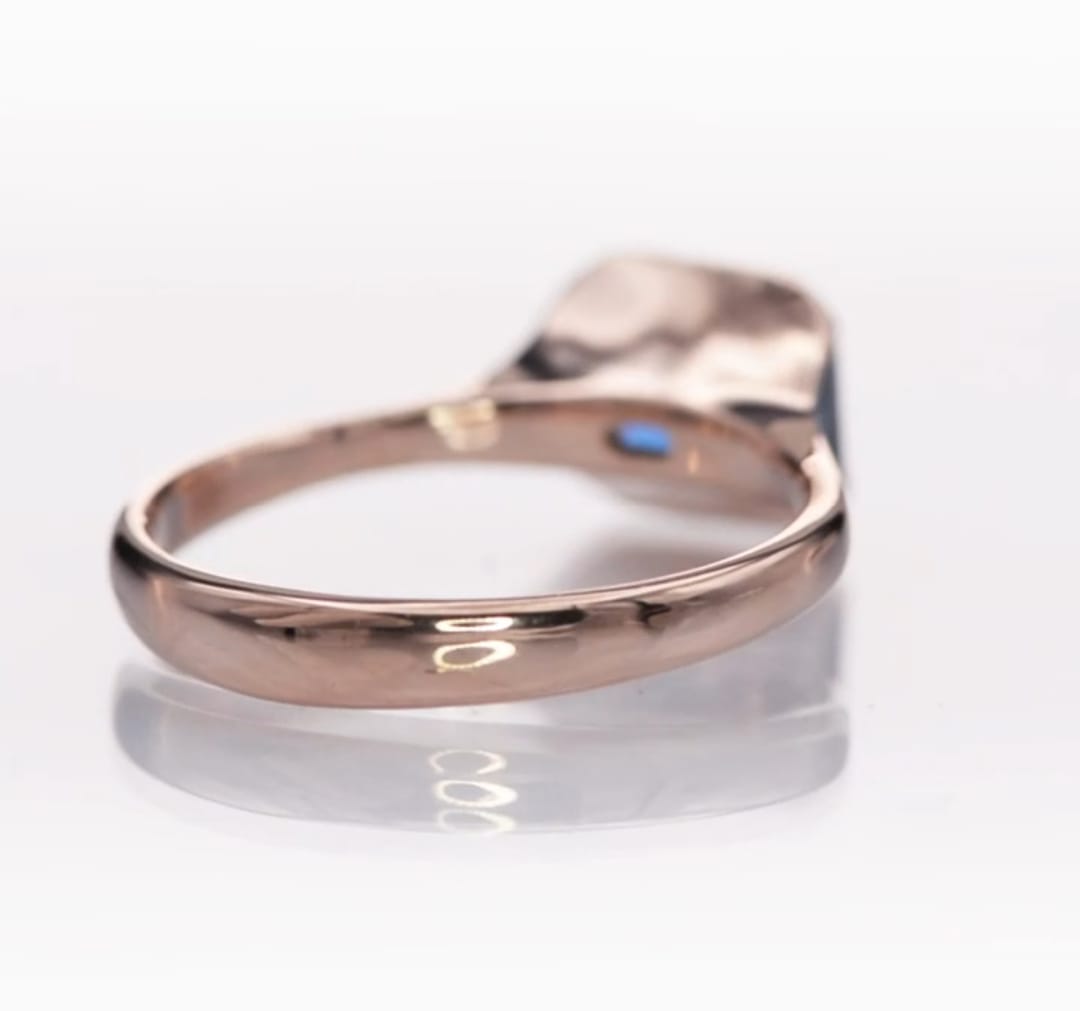 Macro view focusing on the high-polish finish of the minimalist rose gold ring band.