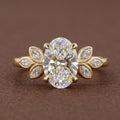 Front studio view of a 3 CT oval cut lab grown diamond engagement ring with marquise leaf side clusters in yellow gold.