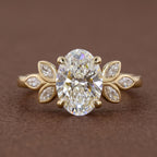 Front studio view of a 3 CT oval cut lab grown diamond engagement ring with marquise leaf side clusters in yellow gold.
