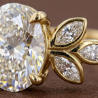 Extreme macro detail of marquise diamond leaf clusters and prong setting on an oval lab diamond ring.