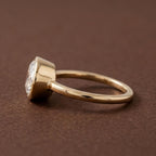 Side profile view showing the low-profile bezel setting and yellow gold band of a 3 CT oval lab diamond ring.