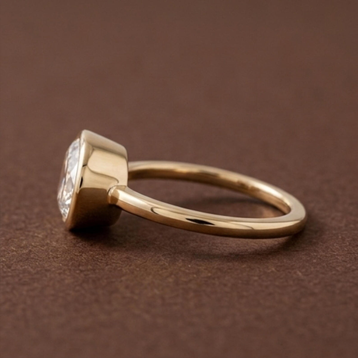 Side profile view showing the low-profile bezel setting and yellow gold band of a 3 CT oval lab diamond ring.