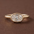Direct top studio view of a 3 CT horizontally set East-West oval lab grown diamond solitaire ring in a yellow gold bezel.