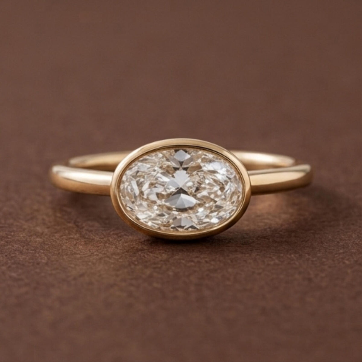 Direct top studio view of a 3 CT horizontally set East-West oval lab grown diamond solitaire ring in a yellow gold bezel.
