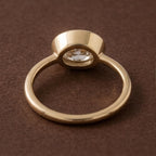 Bottom perspective view of a 3 CT East-West oval lab diamond bezel engagement ring showing band architecture.