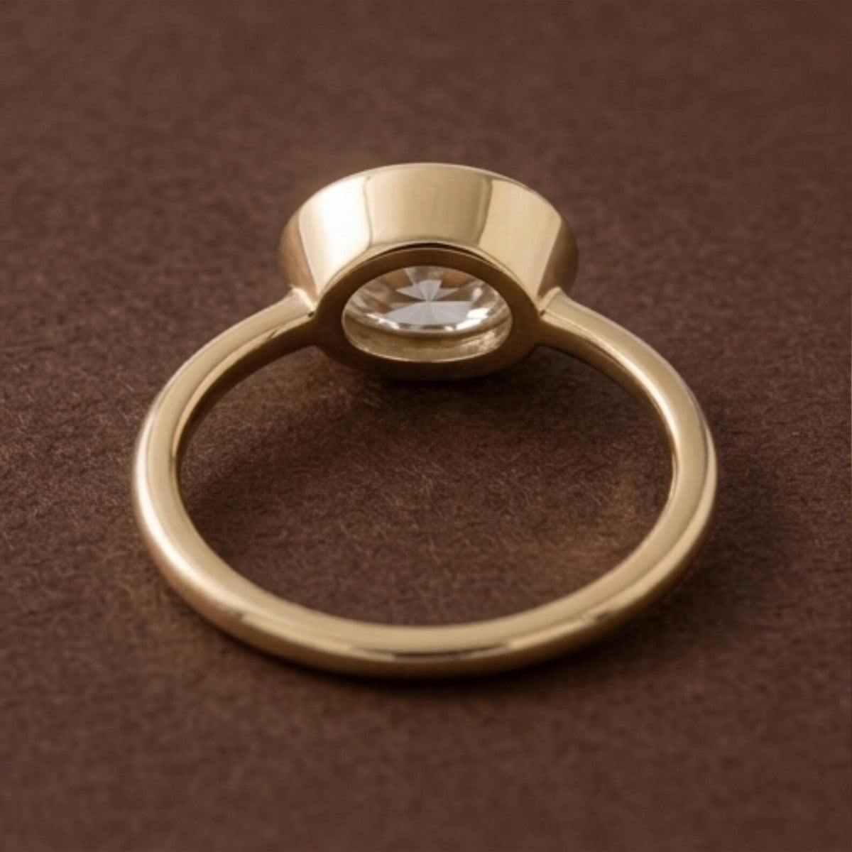Bottom perspective view of a 3 CT East-West oval lab diamond bezel engagement ring showing band architecture.