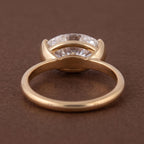 Undergallery perspective view showing open basket construction of a 3 CT oval half bezel ring.