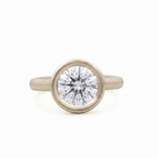 Top-down studio view of a 3 CT round brilliant lab grown diamond in a yellow gold full bezel setting.