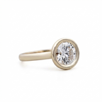 Angled perspective view showing thick dome band and low-profile bezel setting of a 3 CT round diamond ring.