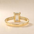 Undergallery view displaying the open basket setting and yellow gold channel band structure of a 4 CT emerald cut diamond ring.