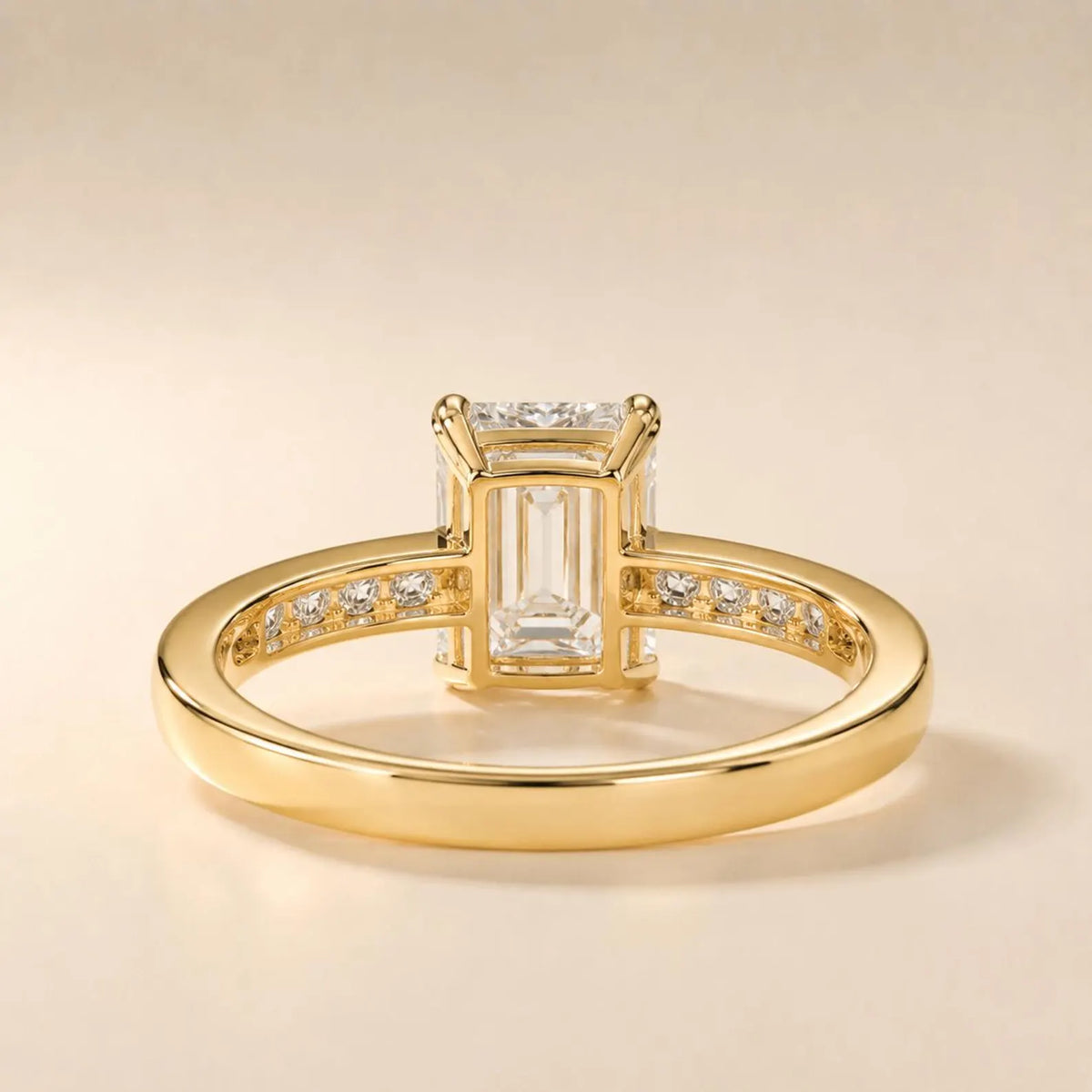 Undergallery view displaying the open basket setting and yellow gold channel band structure of a 4 CT emerald cut diamond ring.