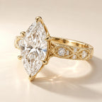 Three-quarter angled view highlighting 6-prong V-tip setting and vintage scrollwork pattern on a 4 CT marquise diamond ring.