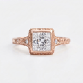 Top view of a 4 CT princess cut lab grown diamond vintage bezel ring in 14K rose gold with hand-carved scrollwork.