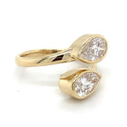 Front top view of a 14K yellow gold Toi et Moi bypass ring featuring two bezel-set pear cut lab grown diamonds.