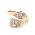 Angled side view of an open cuff bypass ring showcasing two pear cut lab diamonds in solid yellow gold bezel frames.