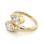 Side profile of a 14K yellow gold Toi et Moi ring highlighting the raised bezel settings for twin pear diamonds.