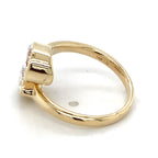 Interior view of a yellow gold bypass ring with twin pear lab diamonds showing the 14K LG hallmark stamp.