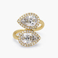 Top view of a 14K yellow gold Toi et Moi bypass ring featuring twin pear cut lab grown diamonds with micro-pavé halos.