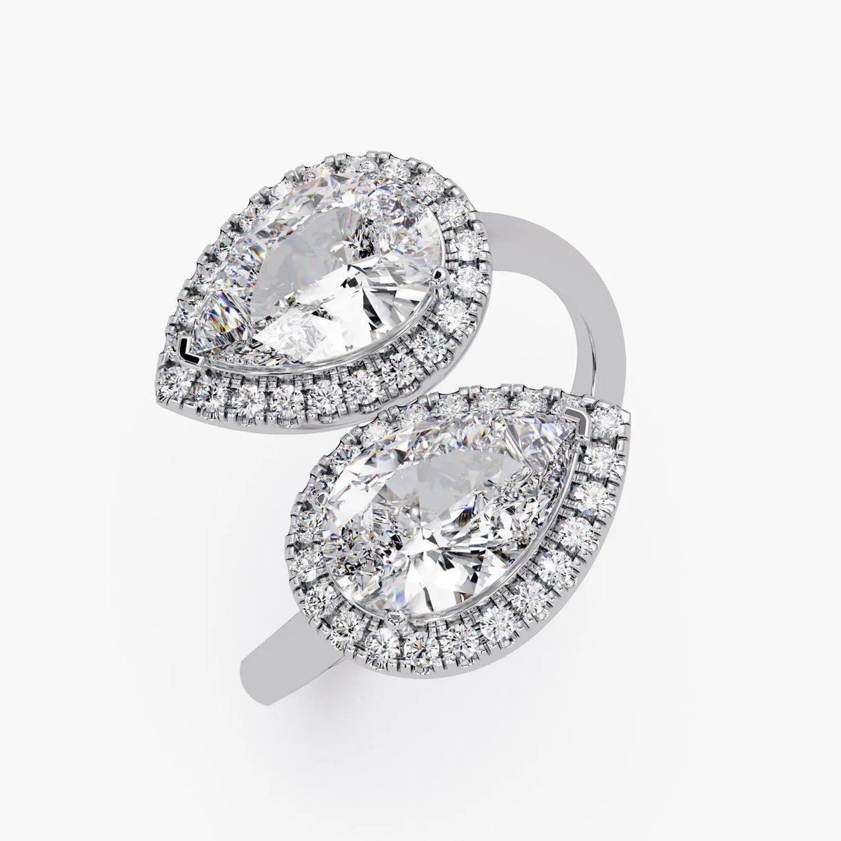 Front view of a white gold Toi et Moi bypass ring featuring two halo-set pear cut lab-grown diamonds.