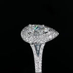 Extreme close-up side profile of a pear cut lab grown diamond highlighting the intricate prong setting, tiered double halo, and split pave band.