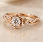 Angled view of a rose gold floral flower halo ring with 2 carat round lab diamond and twisted vine pavé band.