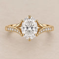 Top view of a 3 CT oval cut lab grown diamond engagement ring with split leaf shoulders and pavé band in yellow gold.