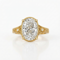 Top view of a 5 CT oval cut lab grown diamond ring with hand-engraved leaf shoulders and milgrain trim in yellow gold.