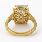 Undergallery profile view of a 5 CT oval lab diamond ring featuring intricate filigree scrollwork in yellow gold.