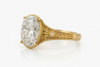 Angled side view of a yellow gold vintage ring featuring a 5 carat oval lab diamond and bezel-set side diamond accents.