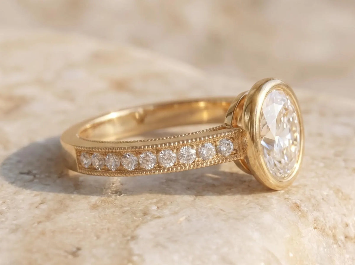 Side profile view of a raised bezel setting holding a 3 CT oval lab diamond with milgrain side diamond accents.