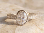Front view of a 3 CT oval lab grown diamond bezel set engagement ring crafted in white gold