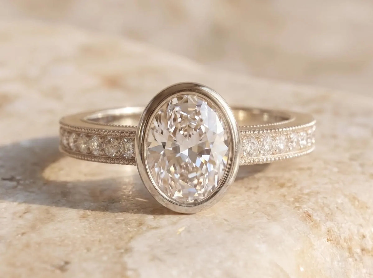 Front view of a 3 CT oval lab grown diamond bezel set engagement ring crafted in white gold