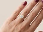 On-hand view of a 3 CT oval cut lab grown diamond bezel engagement ring in yellow gold.