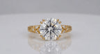 Direct top view of a brilliant 4 CT round lab grown diamond secured by double claw prongs with engraved shoulders.