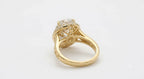 Underside view of a yellow gold vintage ring showing scrollwork filigree undergallery and polished inner shank.