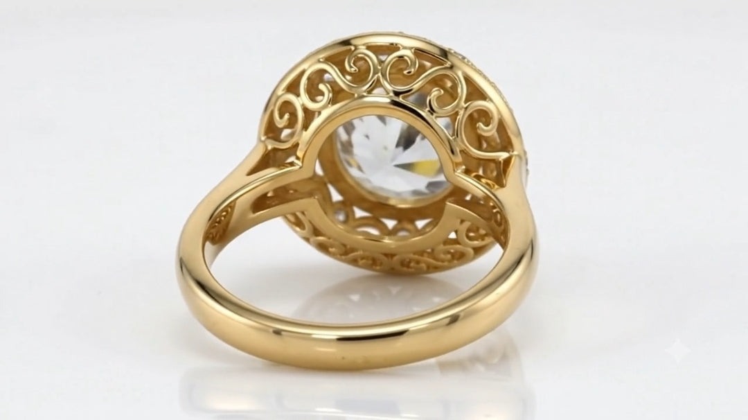 Bottom view of a yellow gold vintage ring showing intricate scrollwork filigree undergallery and smooth inner shank.