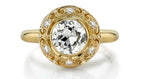 Top-down view of a 4 CT round cut lab grown diamond encased in a bezel setting with diamond-accented filigree halo.