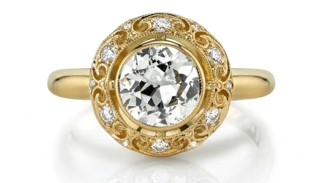 Top-down view of a 4 CT round cut lab grown diamond encased in a bezel setting with diamond-accented filigree halo.