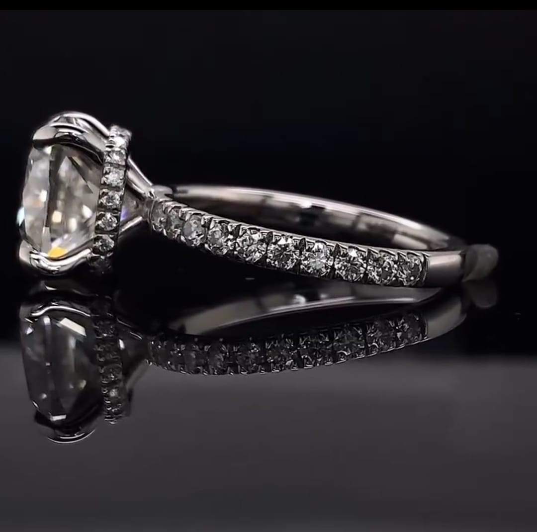 Side profile view of a 3 CT cushion cut lab grown diamond ring featuring a sparkling hidden diamond halo and a pave set band.