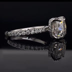 Angled side view highlighting the hidden halo collar and delicate pave diamond band of a white gold cushion cut engagement ring.