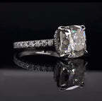Three-quarter angle of a brilliant 3 carat cushion cut lab grown diamond engagement ring reflecting beautifully on a dark surface.