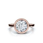 Overhead top view of a brilliant 4 CT round cut lab grown diamond encased in a smooth rose gold bezel setting.