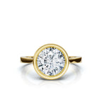 Top-down view of a 4 CT round cut lab grown diamond in a full bezel setting made of 14K yellow gold.