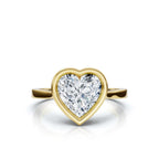Top view of a brilliant 4 carat heart cut lab diamond encased in a protective yellow gold full bezel frame.